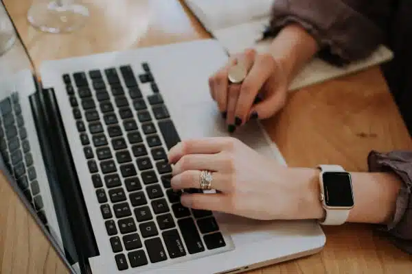 Sideview of a blogger's hands preparing to blog on her laptop.