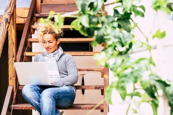 Female blogging outdoors about her travels.